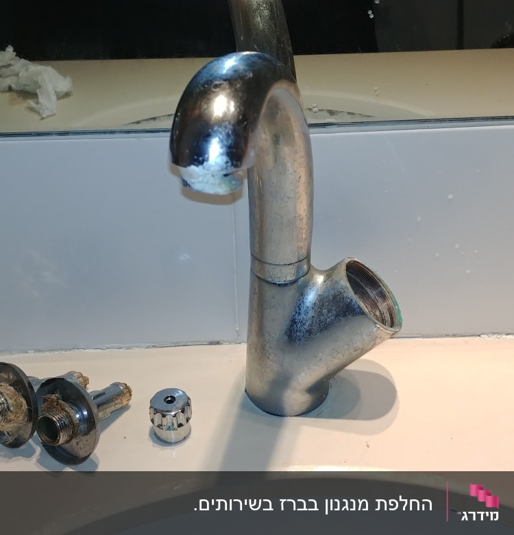 ברז מתכת מפורק עם חלקים על השיש